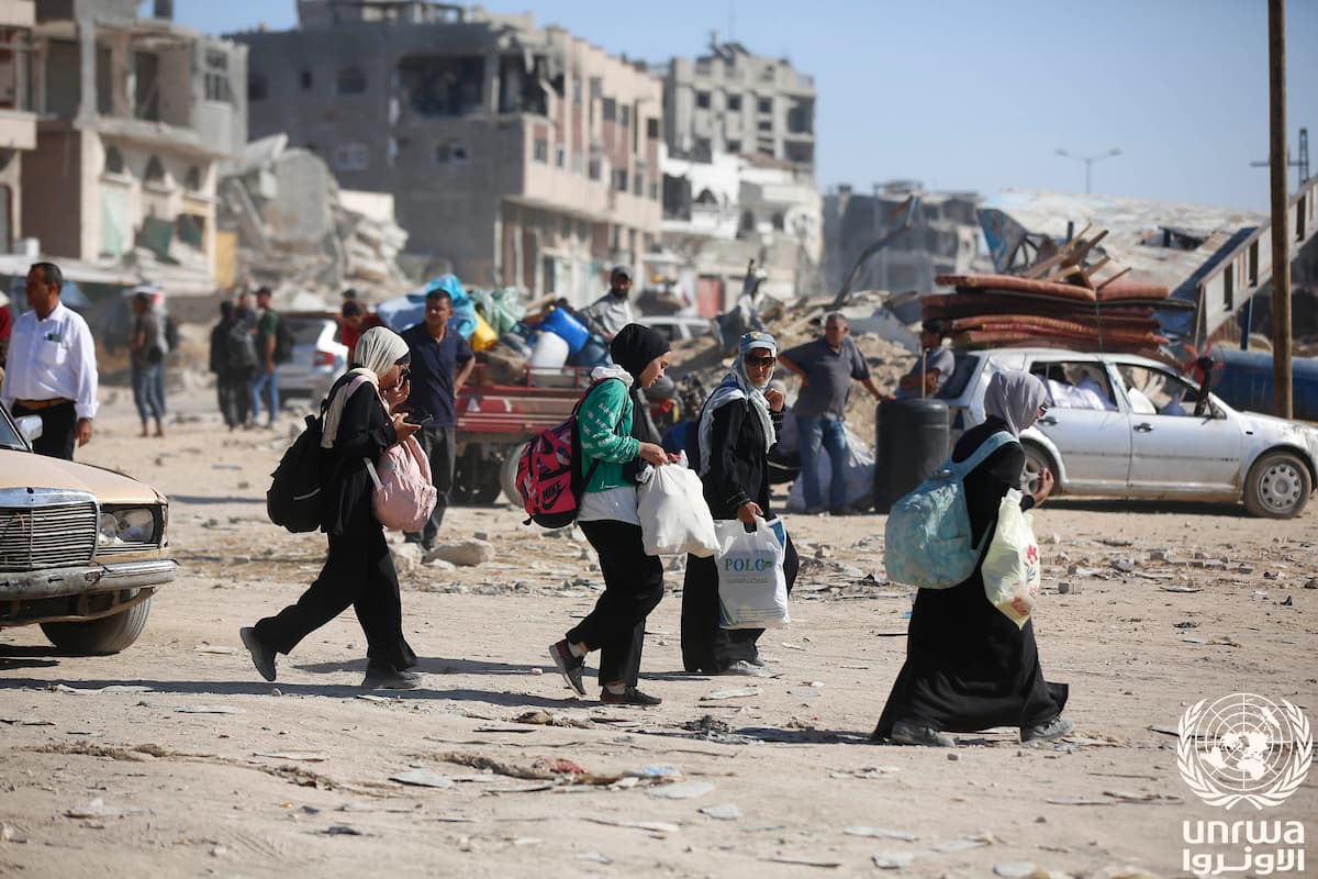 Familias cargan sus pertenencias entre edificios destruidos mientras huyen de Jan Yunis, Gaza